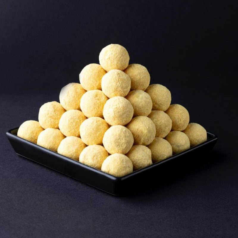 Pyramide aus gelben Ananas-Trüffeln, handgemacht und kunstvoll geschichtet – exotische Pralinen-Spezialität aus der Confiserie.