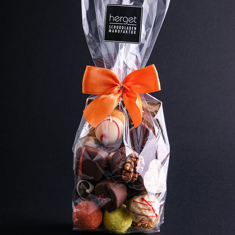 
                  
                    Pralinenbeutel mit oranger Schleife und 250g gemischten Pralinen und Trüffeln 
                  
                