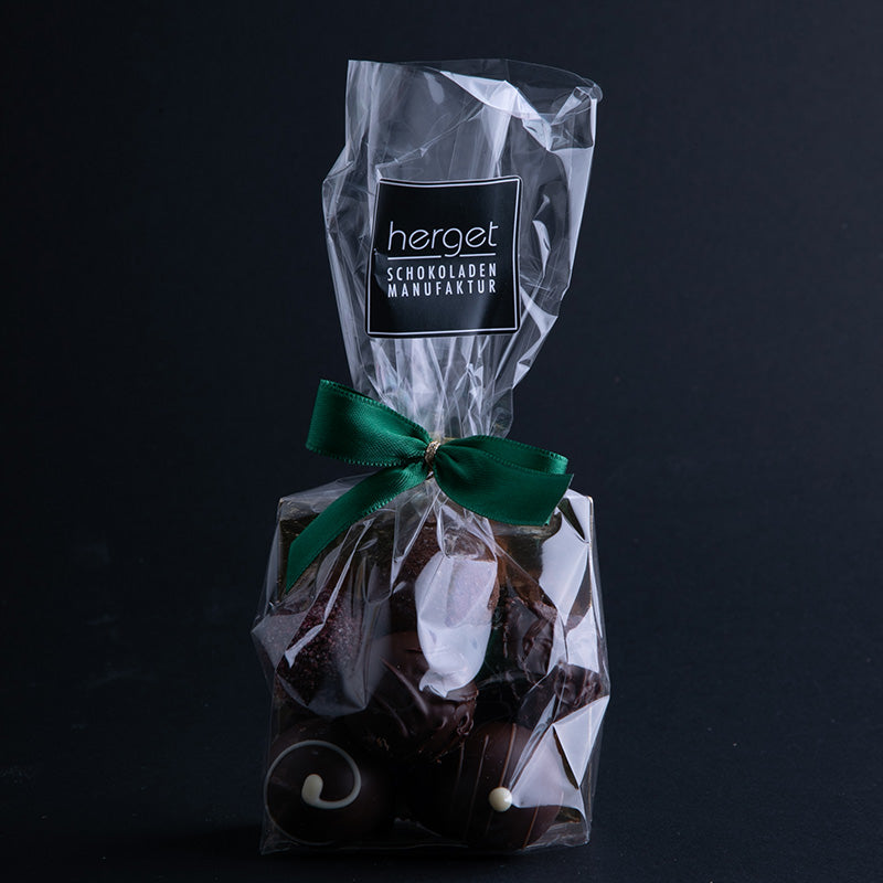 
                  
                    Pralinenbeutel mit grüner Schleife und 150g dunklen Pralinen 
                  
                